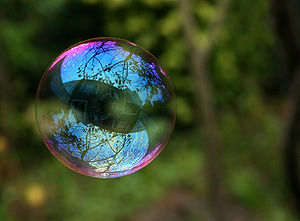 A soapy bubble is a very thin film of soap water that forms a sphere with an iridescent surface.